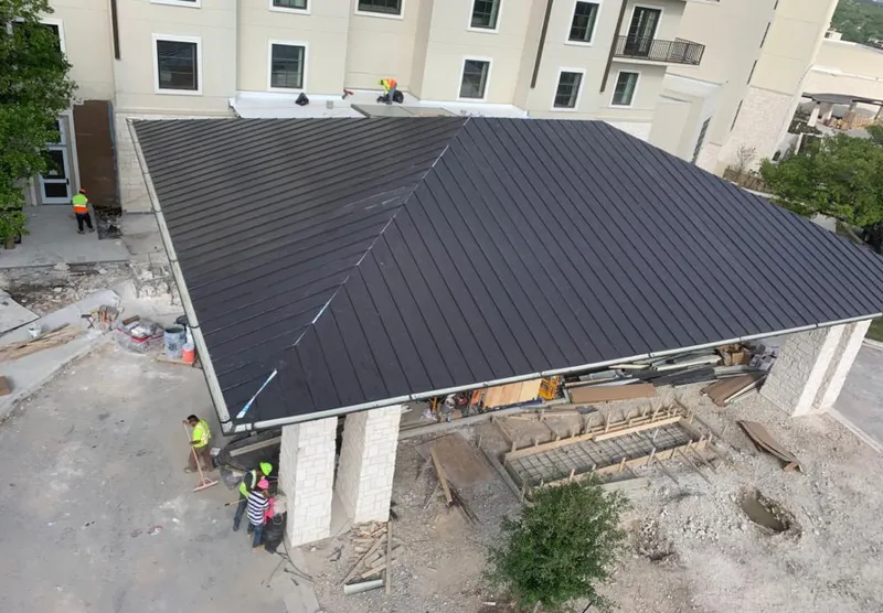Metal roofing installation team working on a commercial building in Robinson
